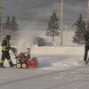 Une souffleuse déneige une patinoire et est filmée par une équipe.
