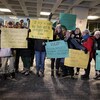 Une quinzaine d'étudiants tiennent des pancartes vantant les mérites du rugby. 