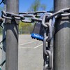 Un cadenas sur les portes d'un terrain de tennis.