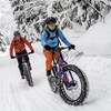 Deux cyclistes pratiquent le vélo à pneus surdimensionnés l'hiver.
