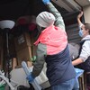 Deux bénévoles de l'organisme Shelter Movers ouvrent les portes d'un entrepôt rempli des meubles et objets appartenant à une femme victime de violence conjugale qui doit quitter son foyer.