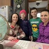 La famille sourit devant un globe terrestre. 