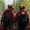 Des pompiers marchent sur un sentier forestier près de l'incendie de Boundary Lake, le 13 mai 2023.