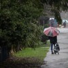 Un homme marche sous un parapluie. 