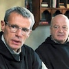 Deux hommes (dont Lambert Wilson) en tenue de prêtres.