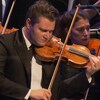 Alexandre Da Costa joue du violon sur scène avec un orchestre.