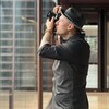 Samian qui prend une photo à travers une vitre.