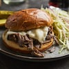 Un burger au bœuf effiloché trône dans une assiette.