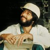Un homme (Al Pacino) portant un casque de chantier, sourit.