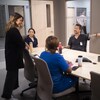 Cinq personne dans une salle de conférence.