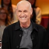 Alain Gravel est assis dans le studio.