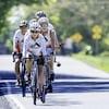 Cinq personnes à vélo sur une route.