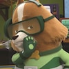 Un petit chien porte un masque de plongée sous-marine vert et un casque d'écoute. Il met la main de sa bouche.