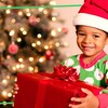 Un enfant avec un bonnet rouge et blanc est heureux de recevoir un cadeau de Noël.