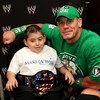 Le lutteur John Cena prend une photo avec un jeune dans une chaise roulante qui porte un chandail de la fondation Make-a-Wish.