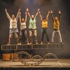 Photo d'un spectacle de cirque : 5 artistes lèvent les bras au ciel