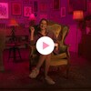 Laïma Abouraja-Gérald est assise dans une chaise dans une chambre décorée de cadres. Le logo de la série L'ABC Intimité et le bouton Jouer sont à droite.
