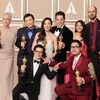 Jamie Lee Curtis, James Hong, Ke Huy Quan, Michelle Yeoh, Jonathan Wang, Daniel Kwan, Stephanie Hsu et Daniel Scheinert posent avec sept statuettes dorées.