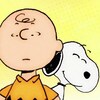 Snoopy se tient derrière Charlie Brown en souriant.