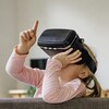 Deux enfants portant des casques de réalité virtuelle dans un salon.