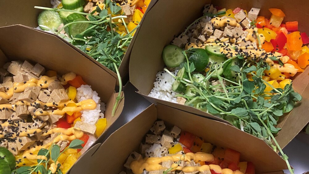 Des boîtes à lunch contenant du poké végétarien au tofu.