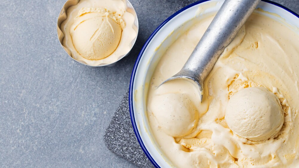 Un bol de crème glacée au pawpaw avec une cuillère à crème glacée.