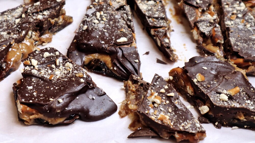 Des écorces de chocolat et de dattes aux bretzels sur un papier parchemin.