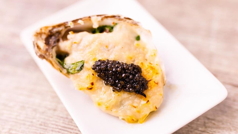 Une huître gratinée dans une assiette.
