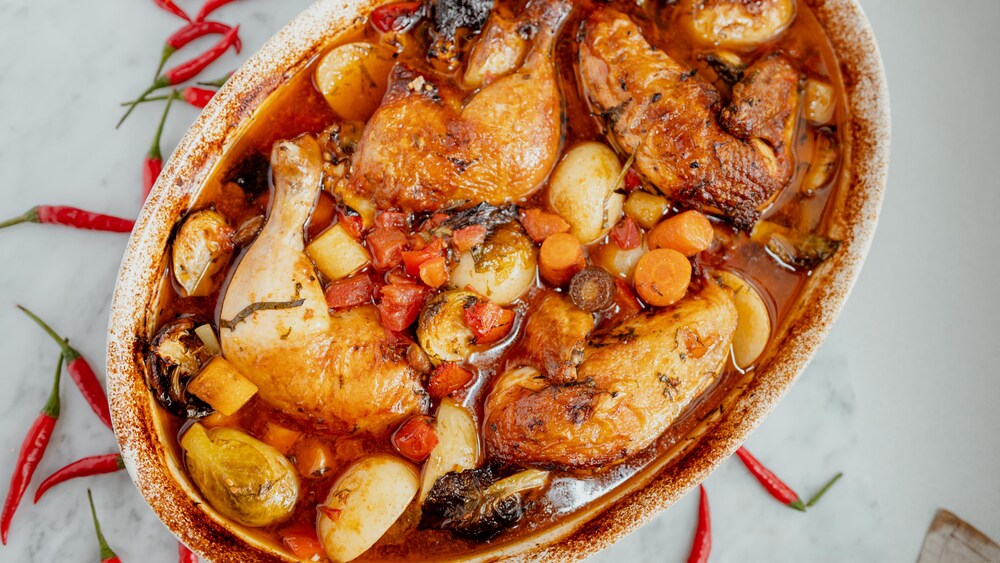 Un plat de cuisson avec un poulet rôti à la portugaise.