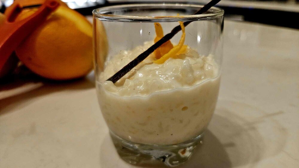 Un petit contenant en verre de riz au lait à l'orange et à la vanille.