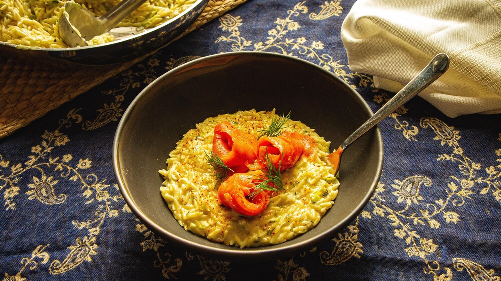 Un bol rempli d'orzo avec du saumon fumé.
