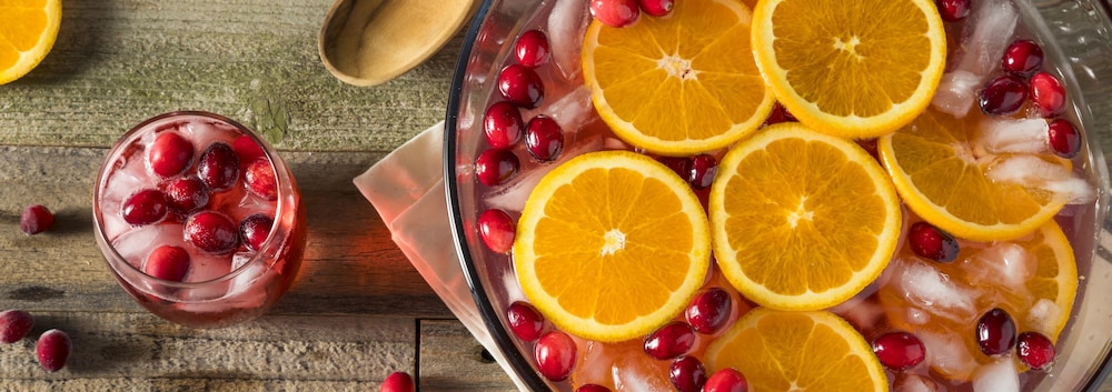 Un grand bol de punch avec deux verres.