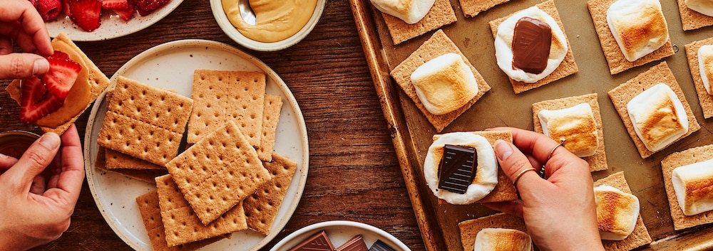 Deux personnes confectionnent leurs s’mores.