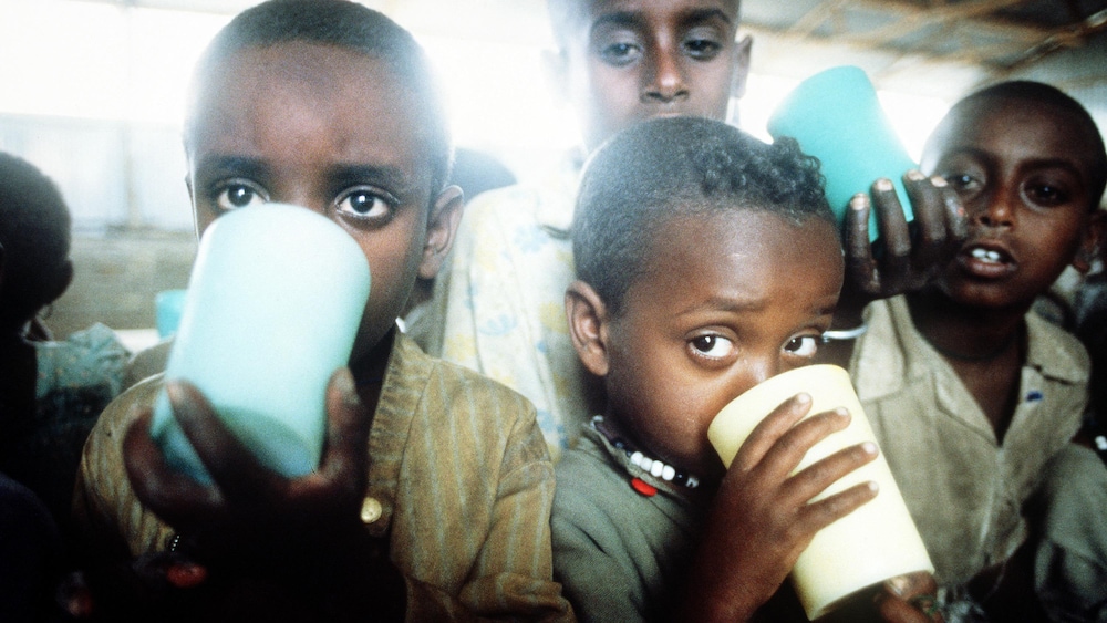 Quatre enfants boivent dans des verres.