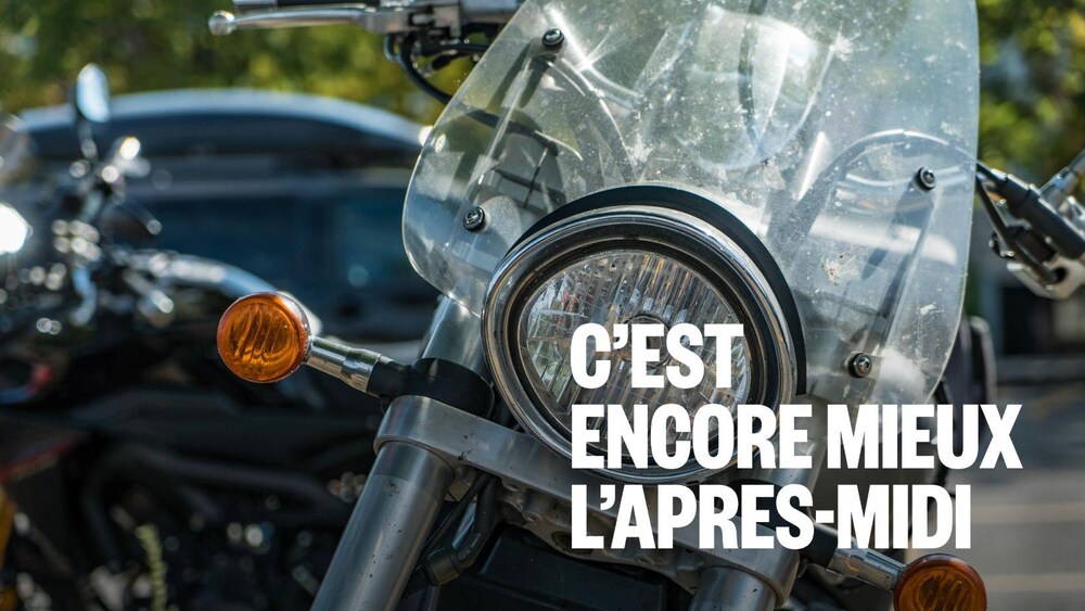 Une motocyclette noire et argentée qui est stationnée.