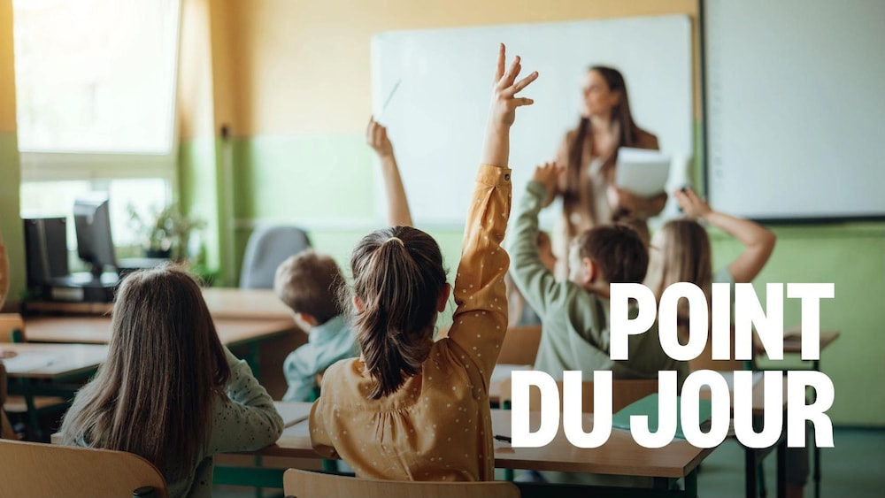 Des élèves lèvent leur main dans une salle de classe.