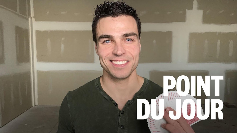 Roger Boucher dans une salle de répétition avec des cartes dans sa main.