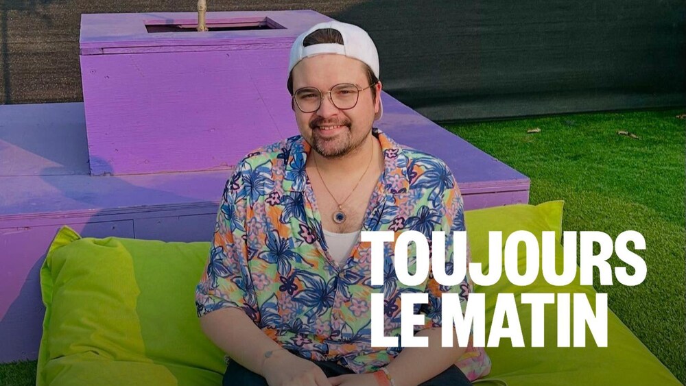 Un homme avec une chemins colorée assis sur un coussin
