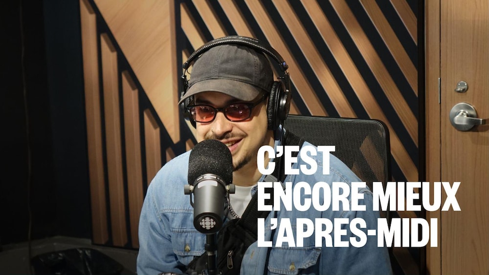 Un homme avec des lunettes assis dans un studio radio.