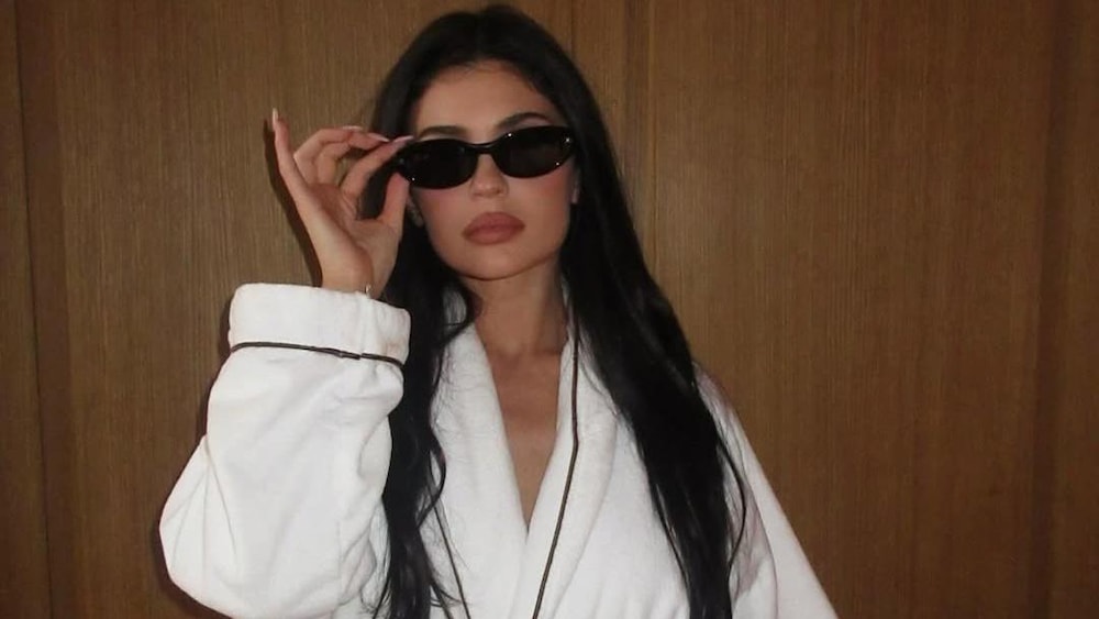 Kylie Jenner, en peignoir porte des lunettes de soleil.