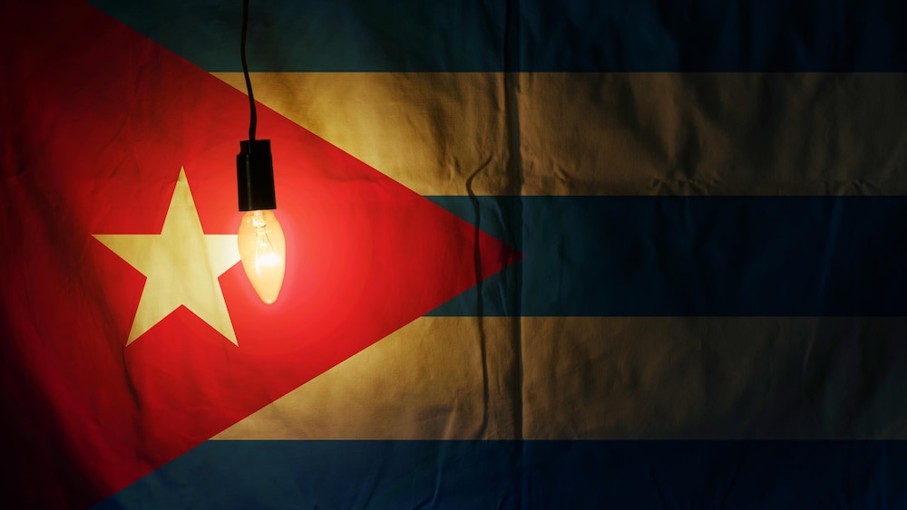 Illustration d'un drapeau cubain à côté d'une ampoule émettant une faible lumière.
