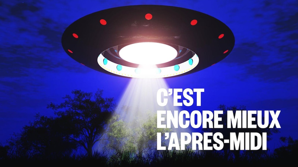 Il y a ovni avec une grosse lumière blanche sur la forêt.