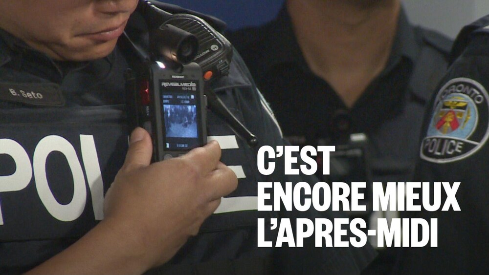 Zoom sur la caméra, plus petite qu'un téléphone cellulaire, sur le gilet d'un policier.