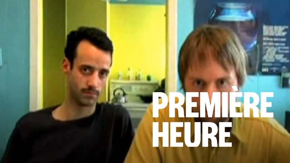 Deux hommes regardent la caméra.