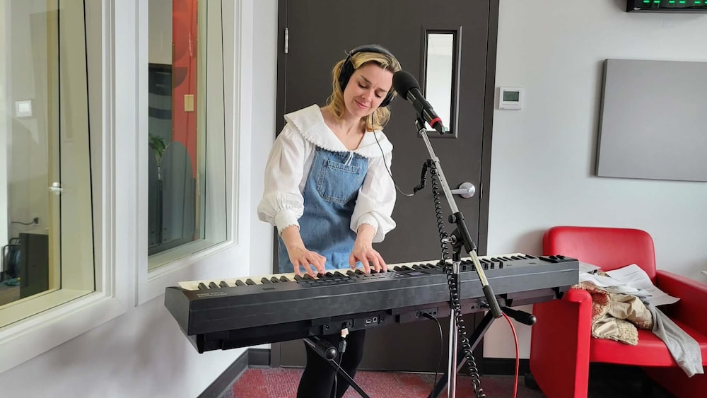 Viviane Audet derrière son clavier dans un studio de radio. 