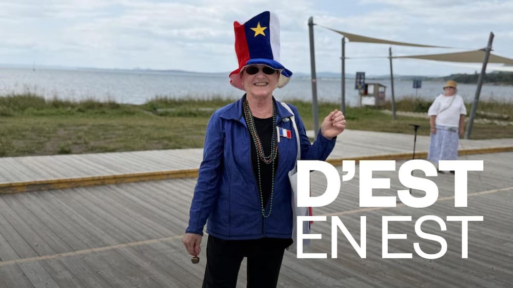 Une femme porte un chapeau à l'image du drapeau de l'Acadie.