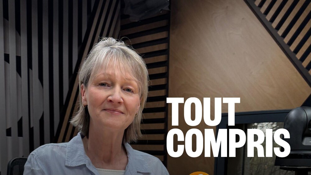 Une femme assise dans un studio d’enregistrement devant un microphone.