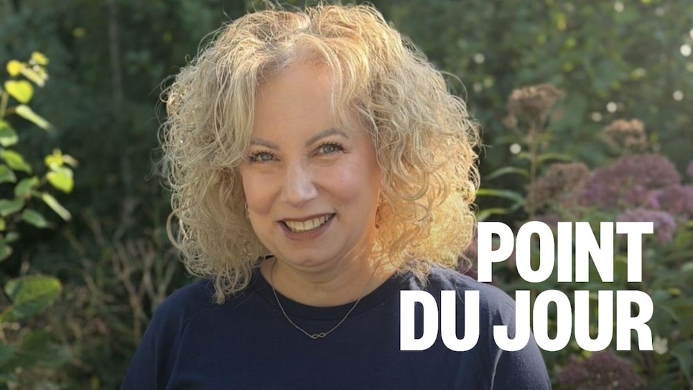 Portrait d'une personne souriante debout dans un jardin.
