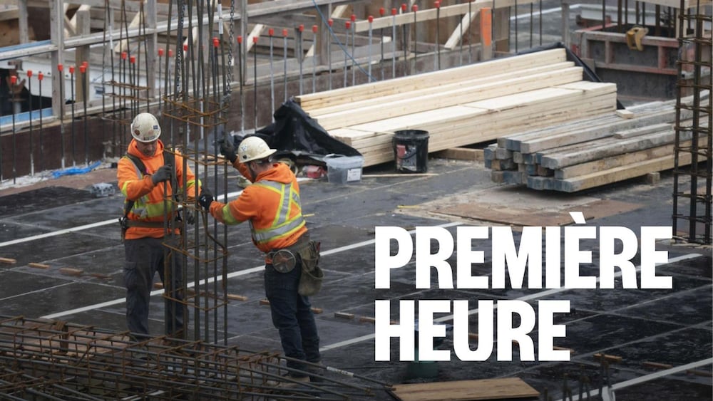 Deux travailleurs manipulent des matériaux sur un chantier.