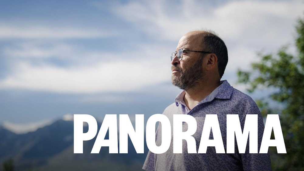 John Fingland regarde dans la distance, dans les montagnes au Yukon, en août 2026.